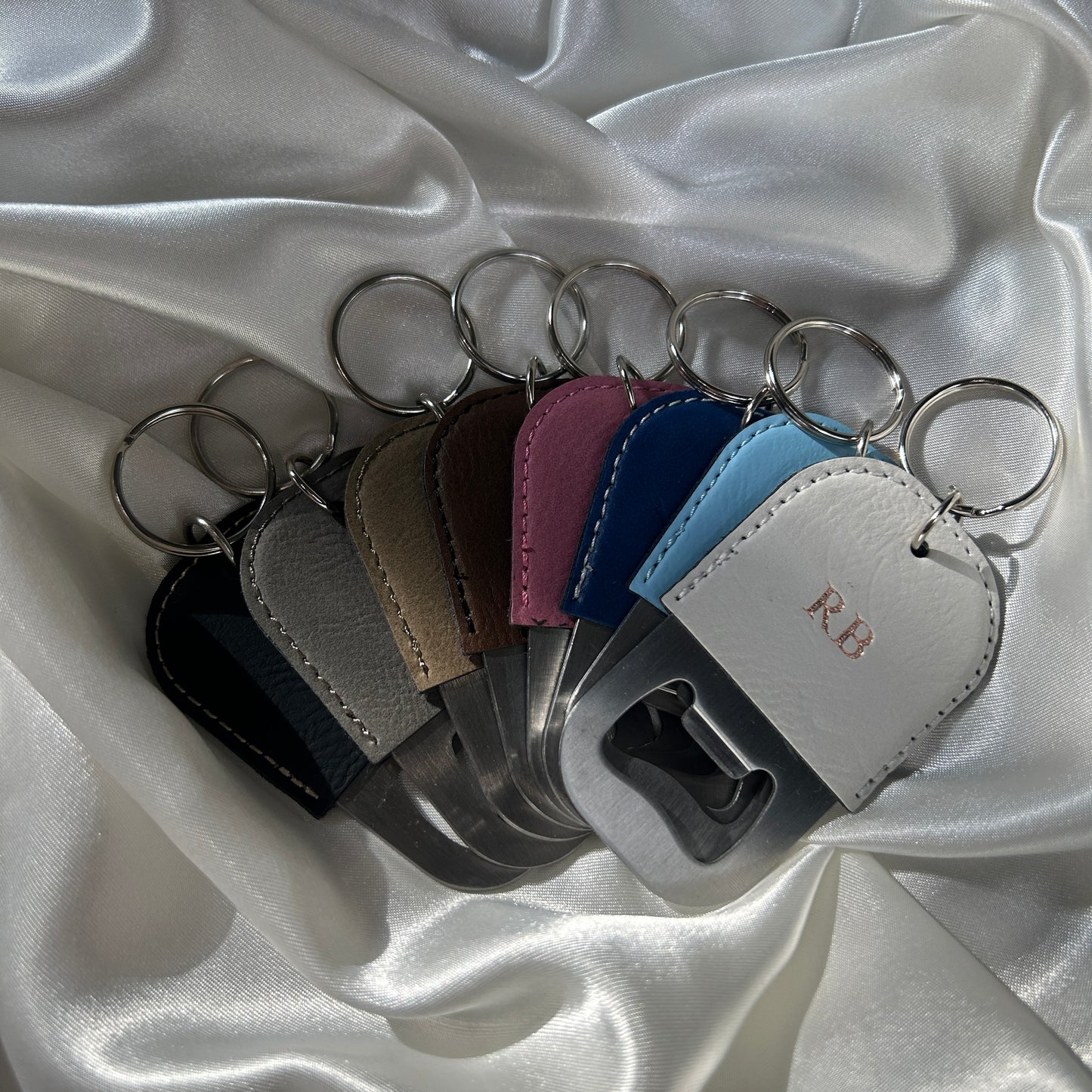 vegan leather bottle opener keychains in colours black, grey, brown, pink, navy, blue and white personalised with initials in rose gold stamping