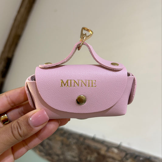 Pink case with 'MINNIE' branding held by a hand against a neutral background